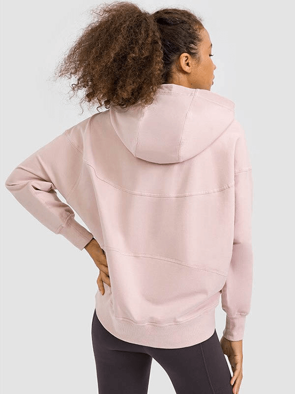 Woman wearing a pink batwing sleeves hoodie, perfect for running, showcasing a loose fit and stylish hooded design, back view.